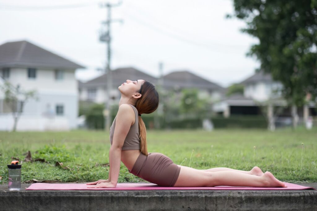 Young Asian woman exercise Do yoga in the park to improve your health.