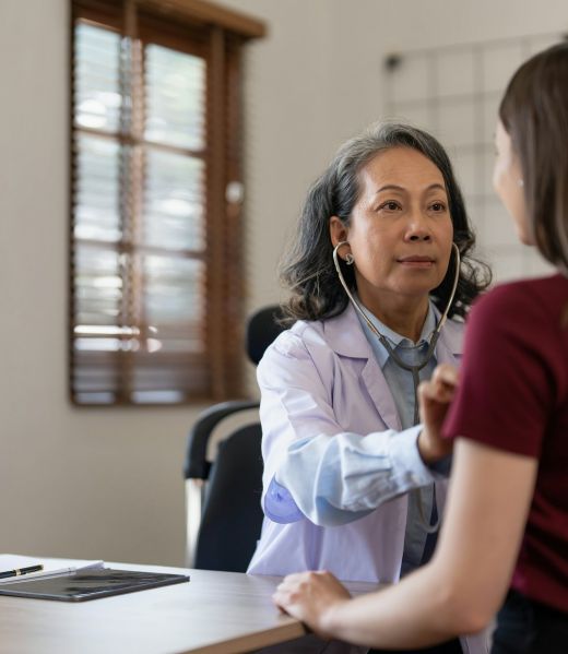 Middle aged female pediatrician listening to young woman's complaints with health problems And write